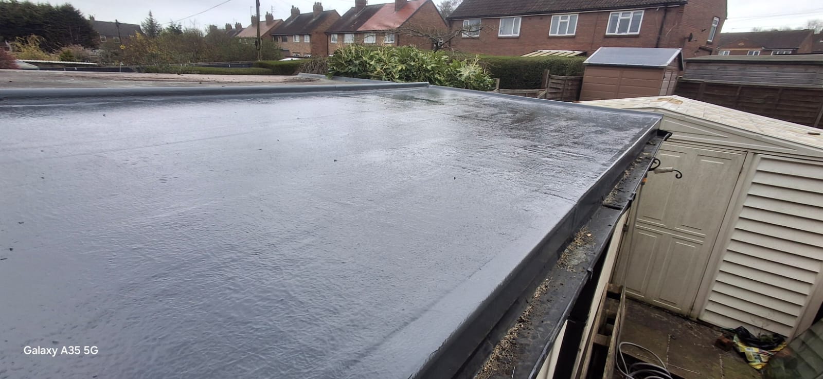 Newly installed dark grey GRP fibreglass flat roof on a Yorkshire home with weather-tight finish