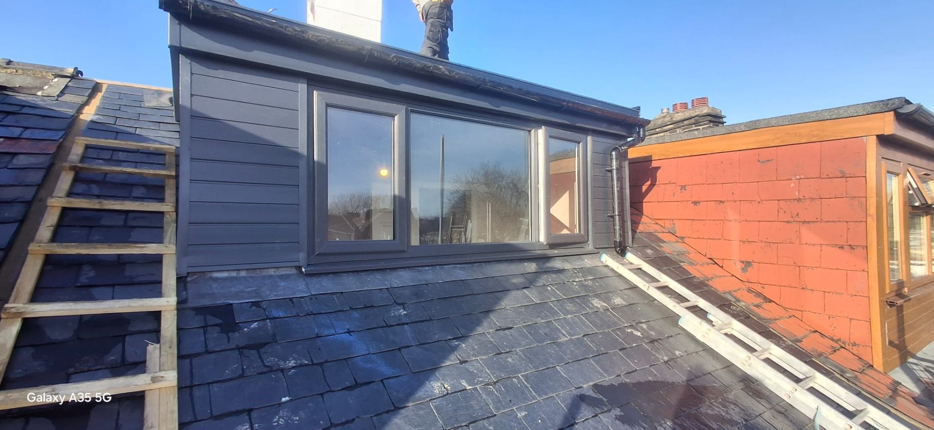 Loft dormer with grey vertical cladding, anthracite windows and re-slated pitched roof