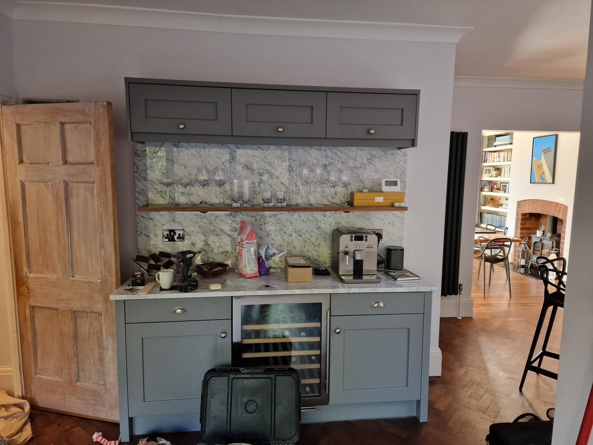 Vaulted kitchen ceiling with skylight and tall arched feature window above marble worktop and butler sink