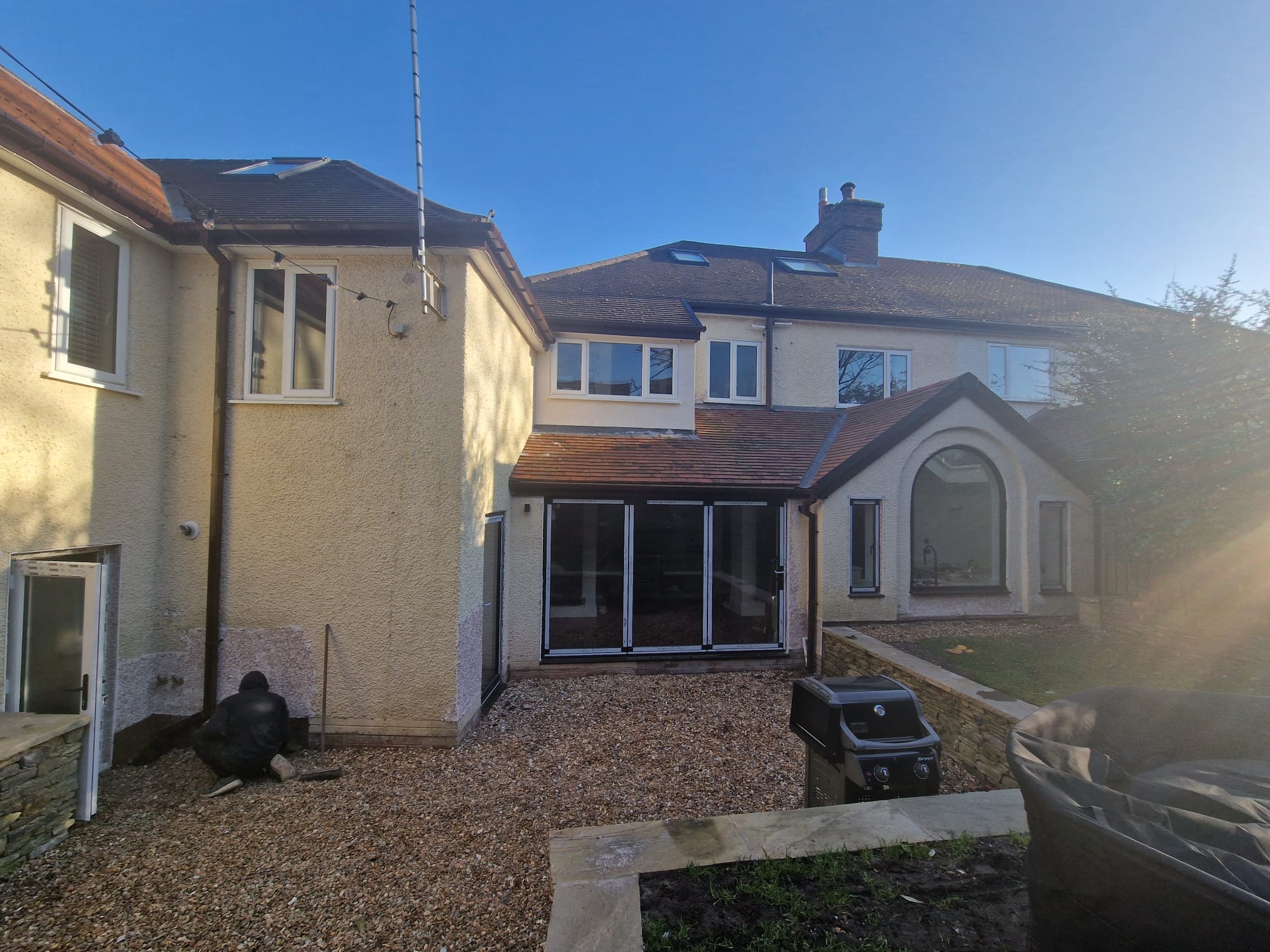 Tiered garden landscaping with golden gravel terrace, hand-built dry-stone wall and timber sleeper steps