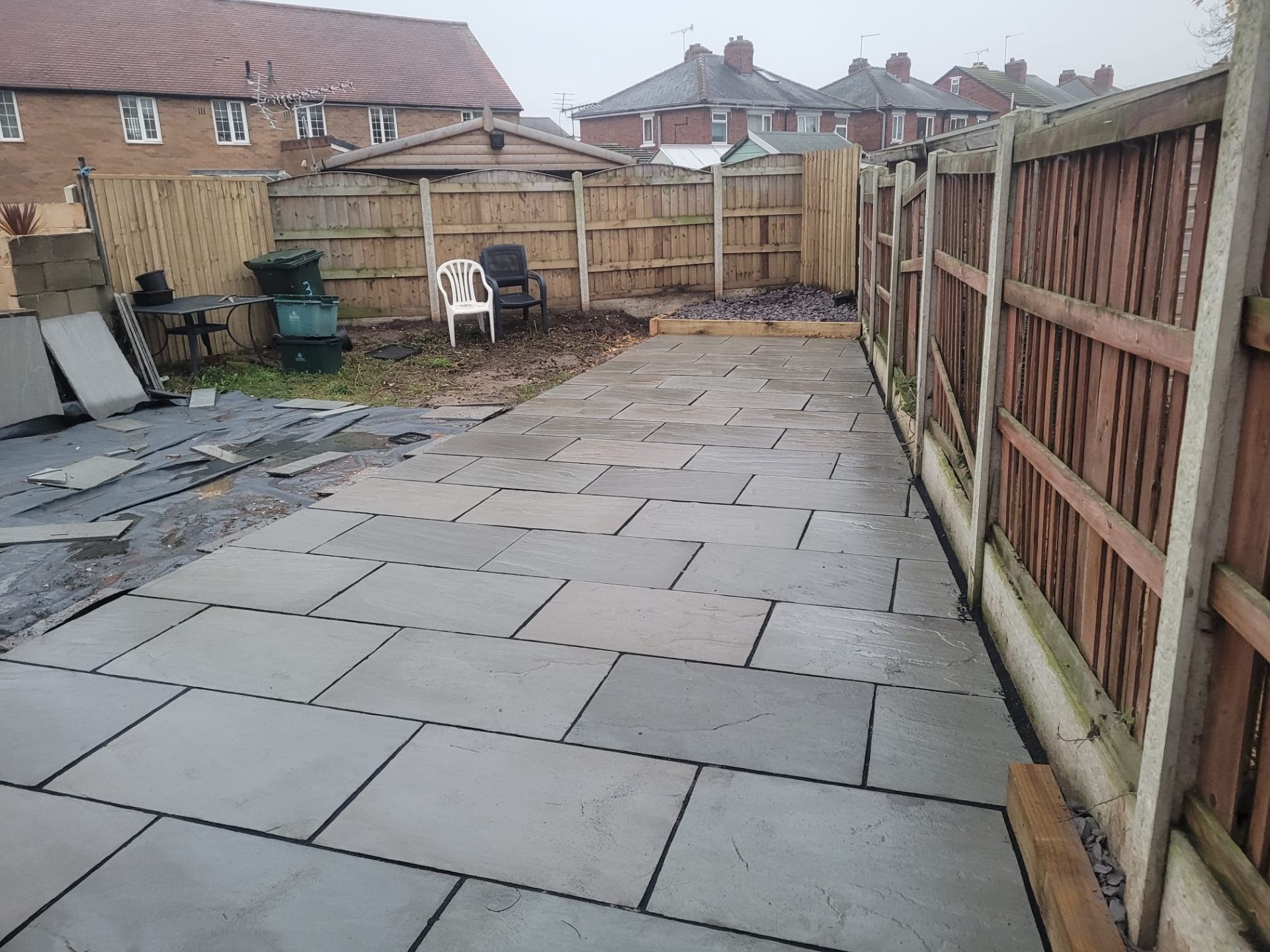 Bespoke black aluminium-framed front door with full-height glazed sidelights fitted into a render facade