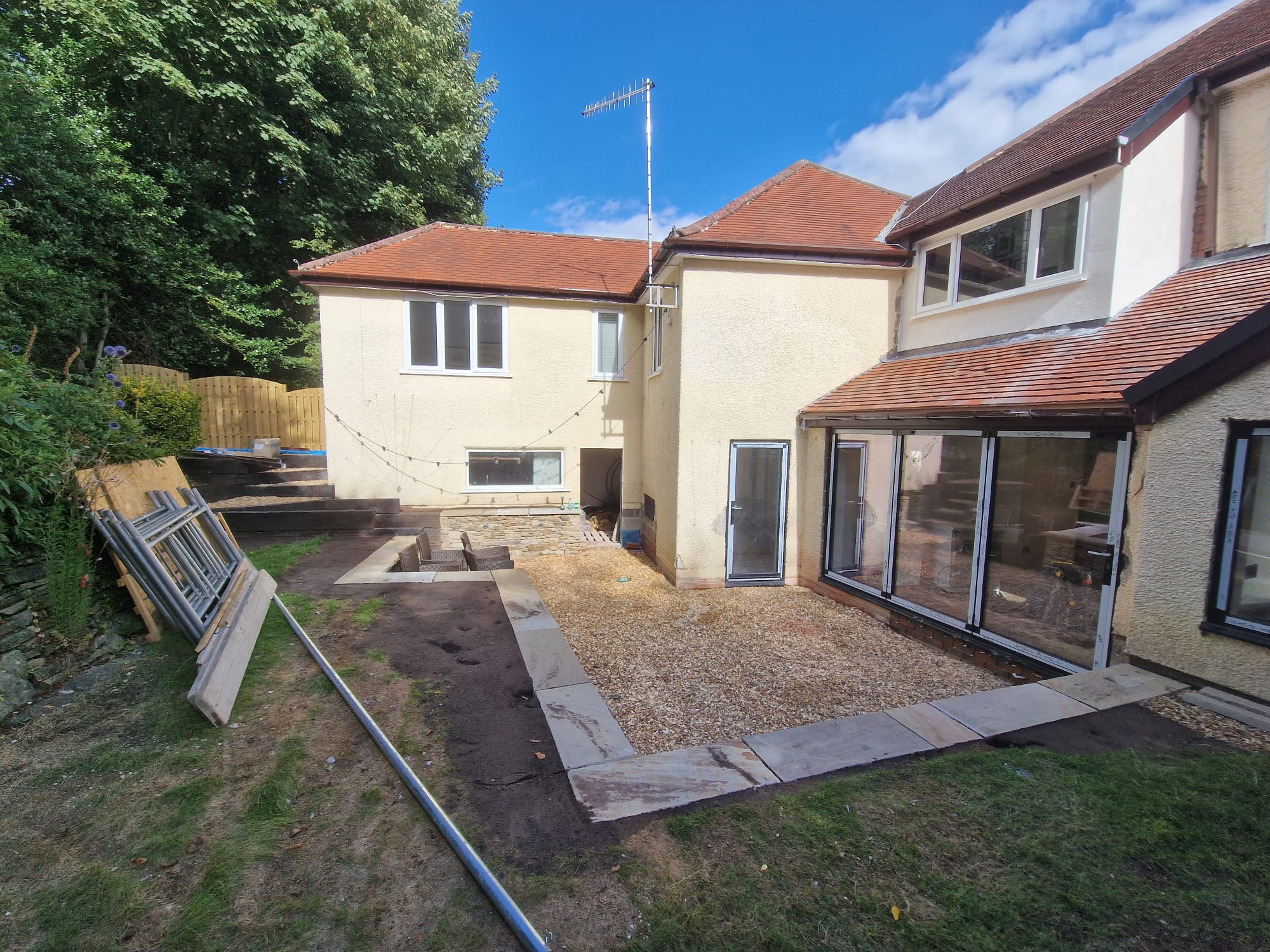 Newly laid riven sandstone patio path running along a fenced garden boundary in a Yorkshire back garden