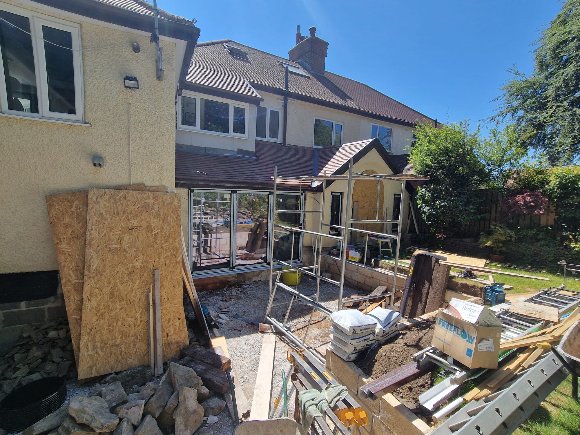 Two-storey side and rear wrap-around extension with bifold doors and arched feature window during build